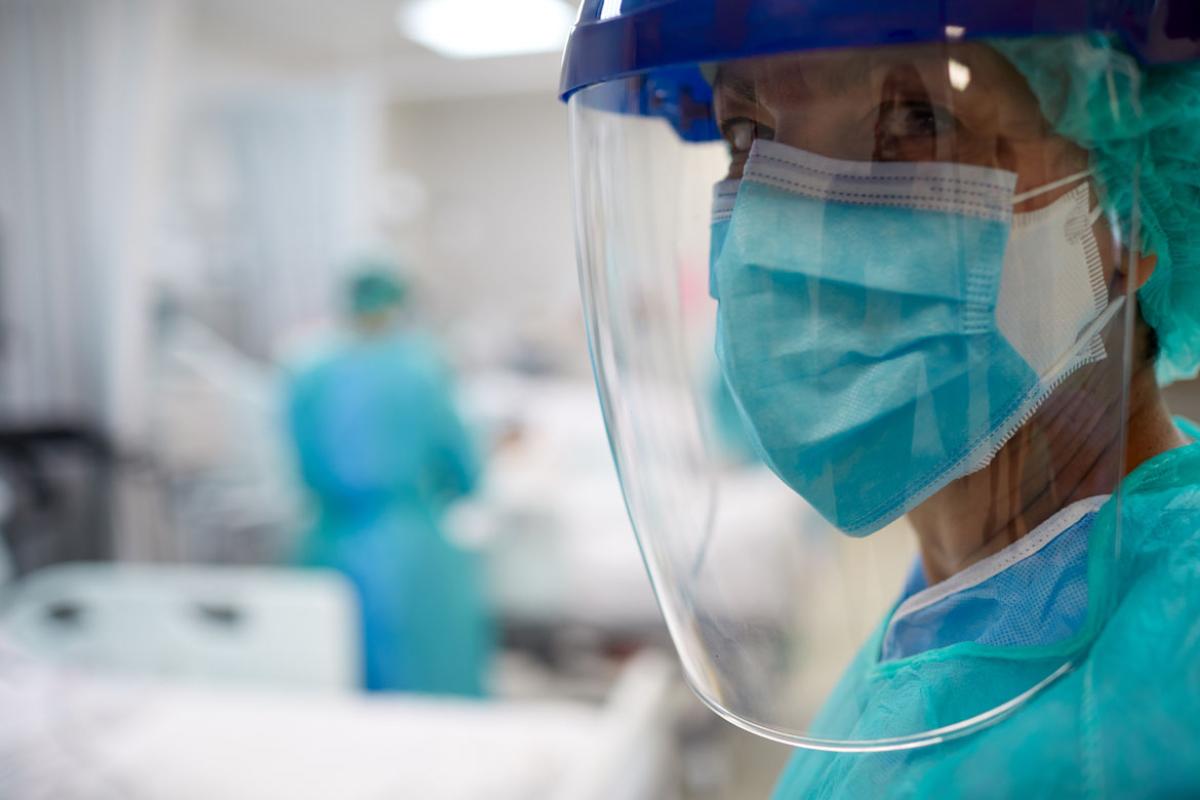 Physician with PPE, including mask, face shield and scrubs_Tight shot right framed