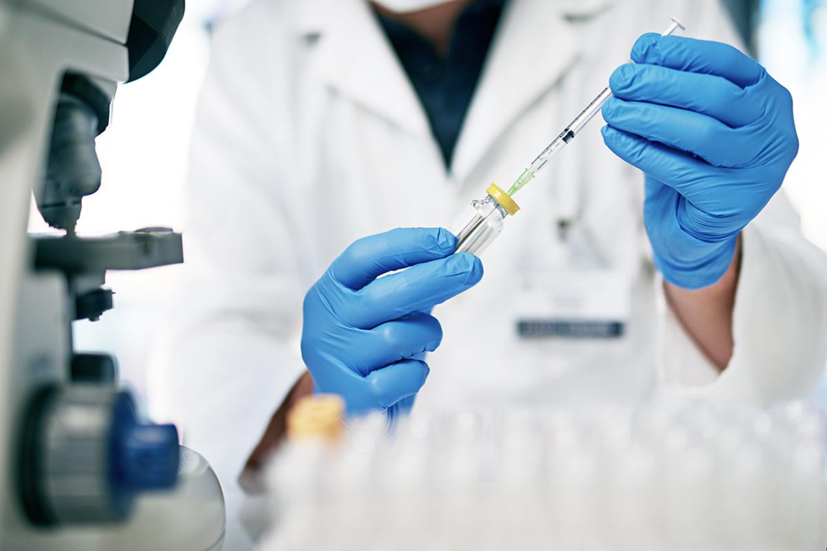 Close up photo of a physician loading a syringe with a vaccine.