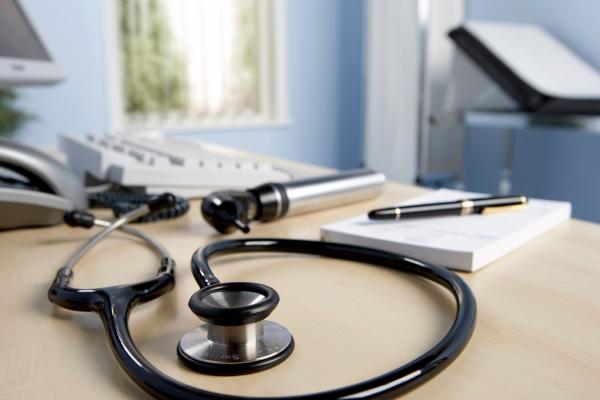 A stethoscope sits on the counter in a doctor's office.